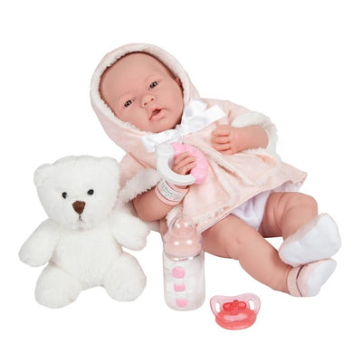 All-vinyl JC Toys La Newborn baby doll in a pink coat with a stuffed bear, baby bottle, and pacifier.