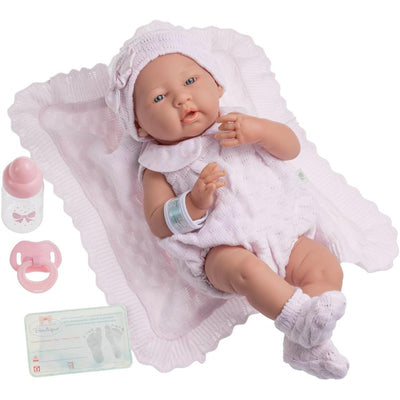 La Newborn Real Girl Baby Doll in a pink knit outfit with accessories, including a blanket, bottle, pacifier, and birth certificate.
