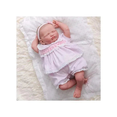 Reborn baby doll, Leonor, wearing a pink outfit with lace detailing, peacefully posed on a soft blanket.