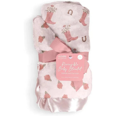 Reversible baby blanket by Jujube featuring a pink floral design and cowgirl boots, tied with a pink ribbon.