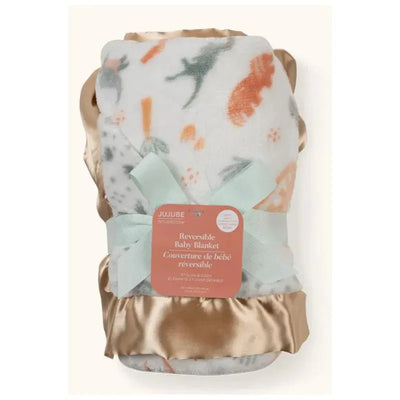 Reversible baby blanket by Jujube, featuring colorful animal prints and soft satin trim, tied with a mint ribbon.