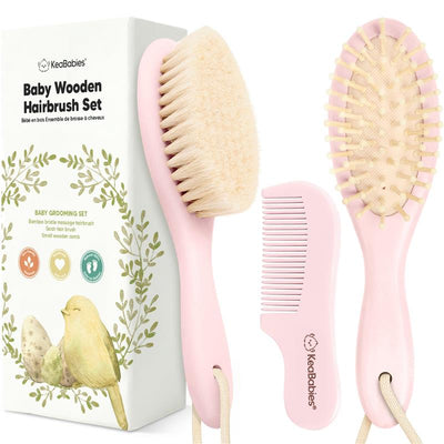 Hair brush and comb set in blush pink for babies, featuring a wooden brush with soft bristles and a small wooden comb.