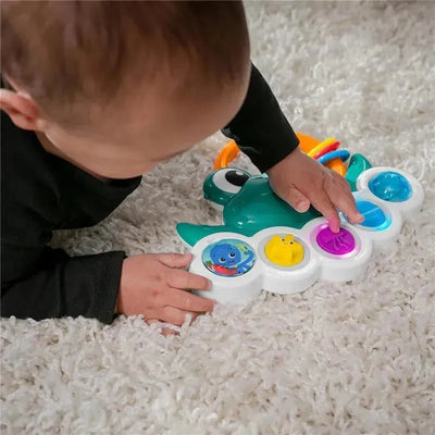Toddler interacting with Kids II Neptune’s Busy Bubbles toy, pressing colorful buttons featuring sea creatures.