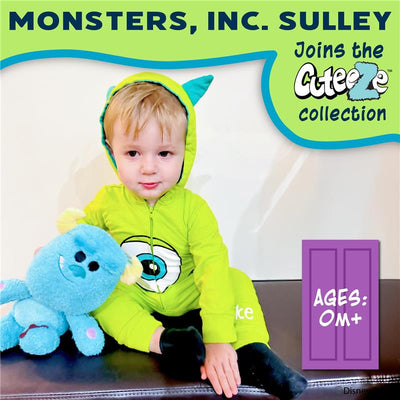 Child wearing a green Sully onesie from Monsters Inc., holding a blue plush character, with product branding visible.