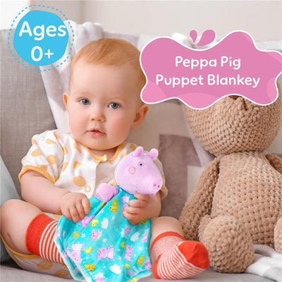 Infant holding a colorful Peppa Pig puppet blankey, sitting beside a soft teddy bear. Ages 0+ indicated.