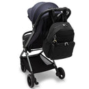 Kipling Maisie Diaper Backpack in Tiny Black Noir attached to a stroller, featuring two zippered pockets and a keychain charm.