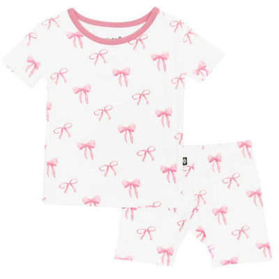 Short sleeve pajamas set featuring a white background with repeating pink bow patterns, ideal for children.