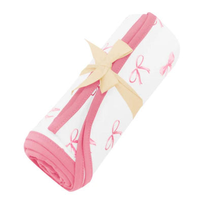 Swaddle blanket designed for infants, featuring a white fabric with pink bow patterns, secured with a yellow ribbon.