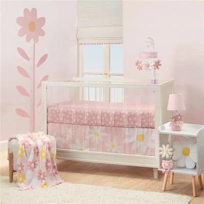 Lambs & Ivy Daisy Dreams 3-piece bedding set features a crib with floral-patterned bedding, a pink throw blanket, and cute decor.
