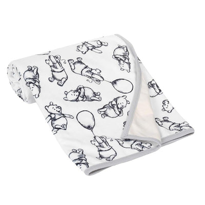 Lambs & Ivy black and white baby blanket featuring playful Winnie the Pooh designs with balloons on a soft fabric.