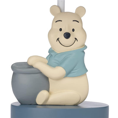 Gray lamp featuring a smiling Winnie the Pooh in a blue shirt, sitting beside a honey pot. Includes shade and bulb.