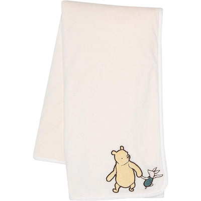 Soft cream baby blanket featuring an embroidered illustration of Winnie the Pooh and Piglet.