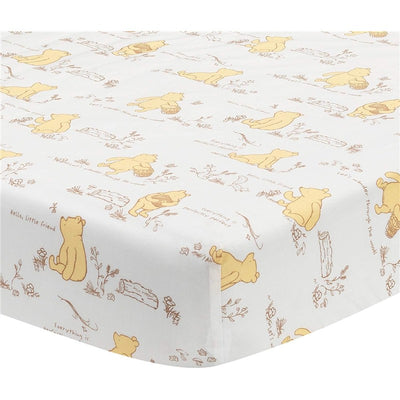 Crib sheet featuring a playful pattern of Winnie the Pooh in yellow, with sketches and phrases on a white background.