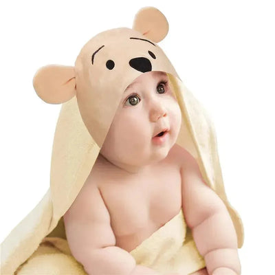 Hooded baby bath towel with Winnie the Pooh design, draped over a cute baby with an expression of curiosity.