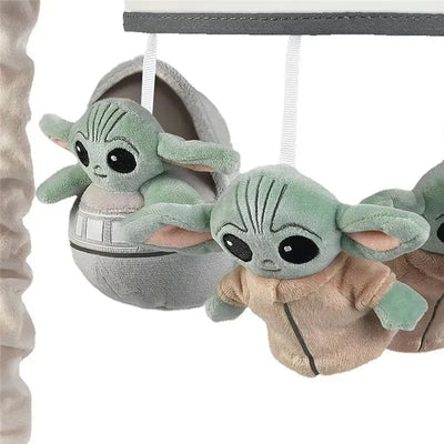 Plush Baby Yoda figures hang from a mobile, featuring one in a hover pod and two in robes, designed for infants.