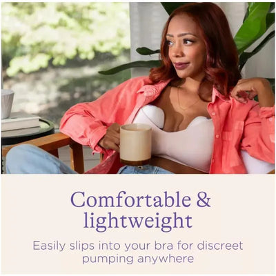 Wearable Lansinoh breast pump shown on a woman sitting comfortably, holding a coffee mug, promoting discreet pumping.