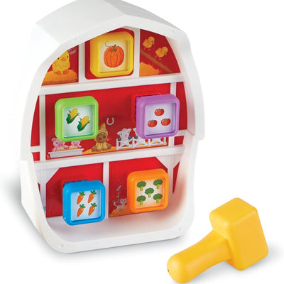 Colorful barn-shaped pounding bench with animal and vegetable blocks and a yellow hammer for skill development.