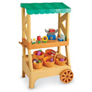 Colorful toy farmstand with various fruits and vegetables in baskets, a scale, and flower decorations for imaginative play.