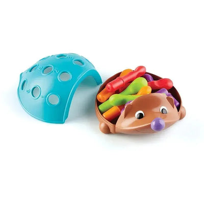 Colorful stacking spikes in a hedgehog-shaped base with a removable blue shell, designed as a fine motor skill toy.