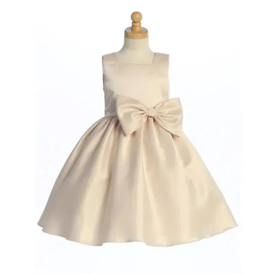 Satin dress for baby girls in chardonnay color, featuring a large bow at the waist and a flared skirt.
