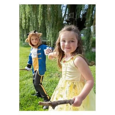Child in a yellow dress with floral details holds a stick, while a boy in a blue Beast Prince costume stands behind her.