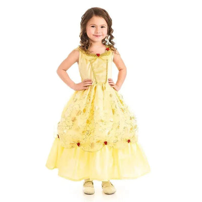 A young girl in a yellow princess dress features floral designs and red accents, smiling confidently with hands on hips.