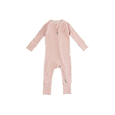 Waffle sleeper in blush pink with long sleeves and a front zipper, designed for infants.