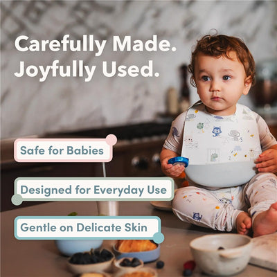 Loulou Lollipop Silicone Bib in Unicorn Ballet design worn by a toddler, with text highlighting its safety and usability features.