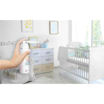 A hand sprays Macrobaby Baby Room Powder Spray in a nursery, showcasing the product with a crib and dresser in the background.