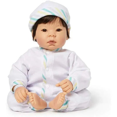 Madame Alexander Beautiful Baby doll with light skin, brown eyes, and black hair, wearing white pajamas and a striped hat.