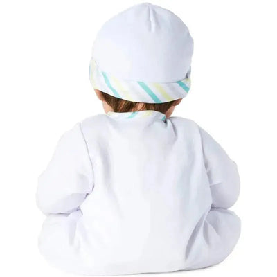Munchkin doll with light skin tone, blue eyes, and brown hair, wearing a white outfit and striped hat, seen from behind.