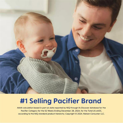 Smiling baby with a silicone pacifier in a gray outfit, being held by a happy adult in a blue shirt.