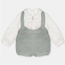 Two-piece set featuring a white shirt with a collared neckline and a green shorts overall with straps and button details.