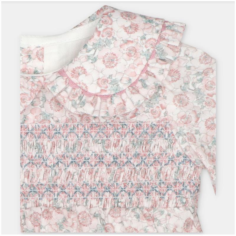 Smocked baby girl romper in woven fabric featuring a floral design with ruffled collar and pink tones.