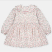 Light pink dress with an all-over floral print, long sleeves, and a ruffled collar.