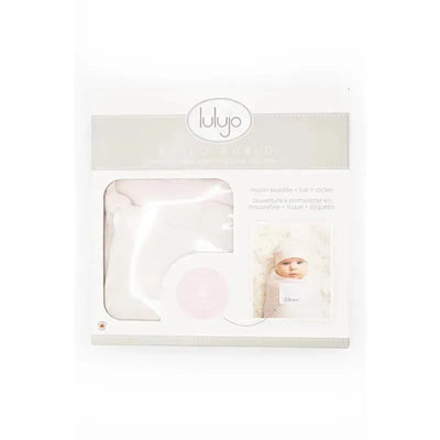 Cotton swaddle set from Mary Meyer, featuring a pink swaddle, a matching hat, and a photo of a swaddled baby.