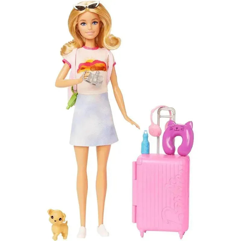 Barbie doll in a casual outfit holding a camera, with a pink suitcase, travel accessories, and a puppy by her feet.