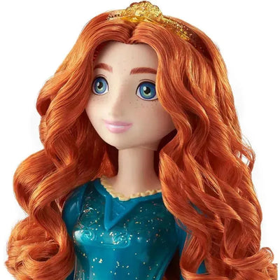 Disney Princess Core Doll Merida features long, curly orange hair, blue eyes, and wears a turquoise dress with glitter details.