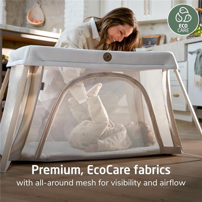 Maxi-Cosi Calao Travel Playard with infant bassinet features all-around mesh for visibility and airflow, shown with a smiling caregiver and baby.