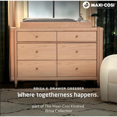 Maxi-Cosi Brisa 6-Drawer Dresser in Onyx Heritage with six drawers and a changing pad, highlighted by cozy decor elements.