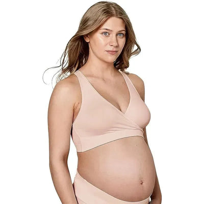 Medela Keep Cool Sleep Bra in Chai, worn by a pregnant woman, features a soft, wrap-around design in a light beige color.