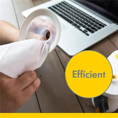 A person cleans a breast pump part with a wipe next to a laptop, highlighting the efficient cleaning process.
