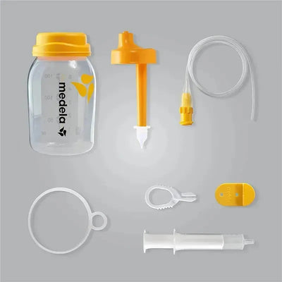Medela Supplemental Nursing System components including a feeding bottle, syringe, and various attachments.