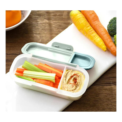 Dip container with celery and carrot sticks, and hummus, placed on a cutting board with additional vegetables.