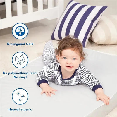 Mini crib mattress with a baby lying on it, featuring safety certifications and hypoallergenic features.