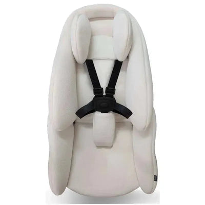 Beige Mima Creo Newborn Snuggle Seat Pad with head support and harness, designed for infant comfort and safety.