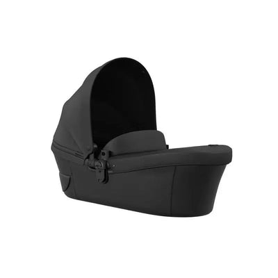 Mima - Xari MAX Carrycot in black, featuring a sleek design with a protective canopy and a secure harness.