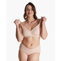 Seamless floral push-up nursing bra in oyster pink, worn by a smiling model, showcasing the scalloped edges and straps.