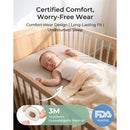 Smart baby thermometer attached to a sleeping infant in a crib, featuring comfort-wear design and hypoallergenic material.