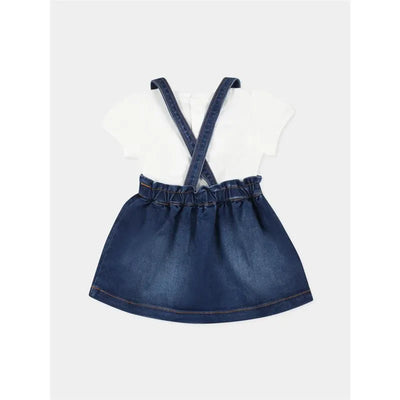 Short sleeve white tee with denim overall skirt featuring crossed straps and gathered waist.